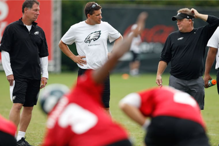 Eagles head coach Chip Kelly talks with offensive coordinator Pat Shurmur and quarterbacks coach Bill Lazor. (David Maialetti/Staff Photographer)