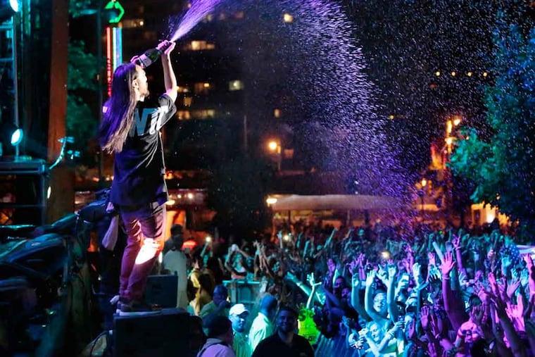 Steve Aoki sprays champagne on the crowd while performing on the Liberty Stage during the Budweiser Made in America Festival, on the Ben Franklin Parkway, in Philadelphia on August 30, 2014. ( ELIZABETH ROBERTSON / Staff Photographer )