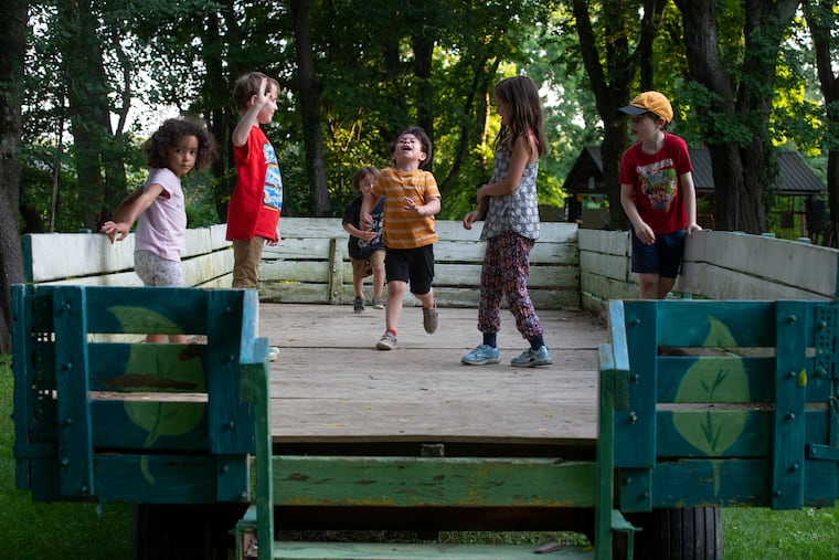 Children play on a large wagon at a potluck dinner at Awbury Arboretum on June 15, 2022. It is our job and obligation as adults to wrestle the world into being a place where kids can feel safe, writes Gwen Snyder.