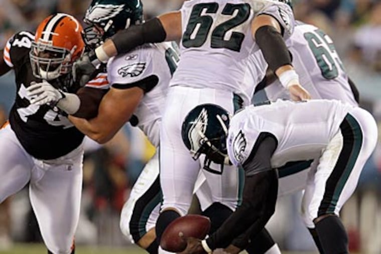 Eagles fans hope that Michael Vick won't drop the ball in the face of defensive pressure. (David Maialetti/Staff Photographer)
