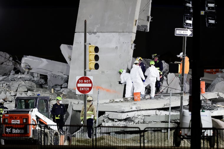 Investigators examine the demolished parking garage in Grays Ferry on Sunday, April 12, 2026.