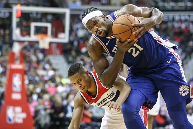 Sixers' Joel Embiid grabs the loose ball from Wizards' Tim Frazier during the 3rd quarter at the Capital One Arena in Washington, DC, Wednesday, October 18, 2017. Wizards beat the Sixers 120-115. STEVEN M. FALK / Staff Photographer