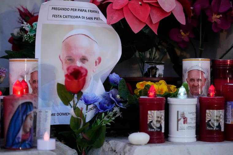 Candles near pictures of Pope Francis outside the Agostino Gemelli Polyclinic in Rome on Sunday, Feb. 23, 2025. The Pontiff has been hospitalized there since Feb. 14.