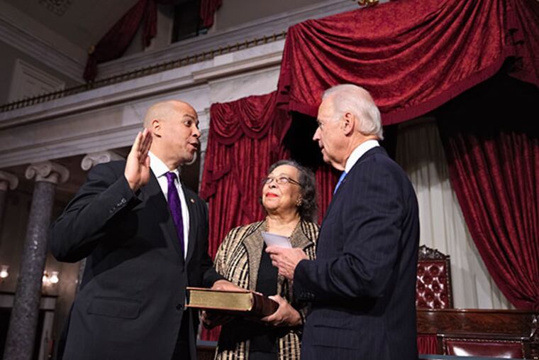 Sen. Cory Booker, D-N.J., repeats the oath of office during a ceremonial swearing-in ceremony with Vice President Joe Biden, acting in his Constitution role as president of the Senate, Thursday, Oct. 31, 2013, on Capitol Hill in Washington. They are joined by Sen. Booker’s mother, Carolyn Booker, center. Earlier, Booker was officially sworn in on the Senate floor. (AP Photo/J. Scott Applewhite)