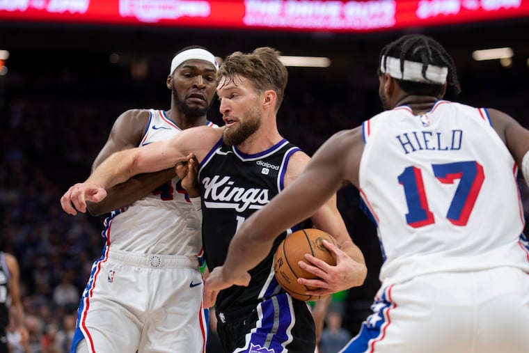 Sacramento's Domantas Sabonis drives to the basket as Sixers forward Paul Reed (left) and guard Buddy Hield defend.