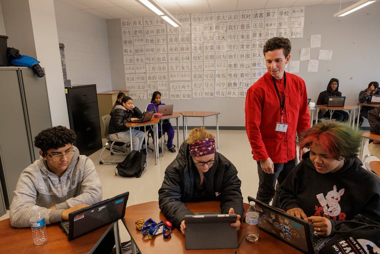 File: Teacher Micheal A. Nusbaum checks with students Brandon Martinez, 15, Adriana Bruce, 16, and Marialyz Daniels, 16, all 10th graders during Mandarin class at Brimm Medical Arts High School in Camden. The Camden district is offering a $10K signing bonus to hire teachers for hard-to-fill vacancies.