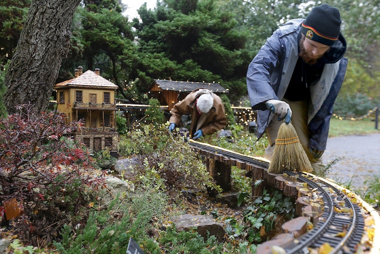 Micah Christensen, right, and Vince Marrocco, left, work on the holiday display in the Garden Railway at Morris Arboretum in Philadelphia, PA on November 13, 2018. DAVID MAIALETTI / Staff Photographer