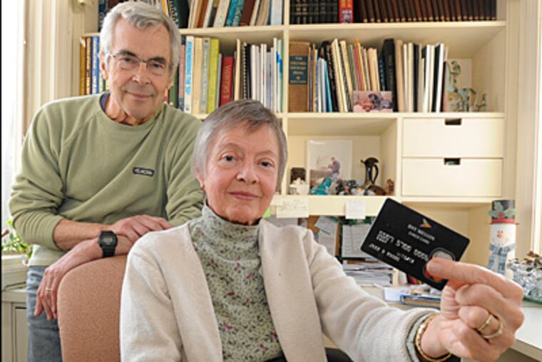 Joan Moore, holding her ATM card, with her husband, Jim. "What are all these weird withdrawals?" she recalls asking her husband. All told, a thief had looted $11,000 from their account from a string of ATMs. (Clem Murray/Staff)