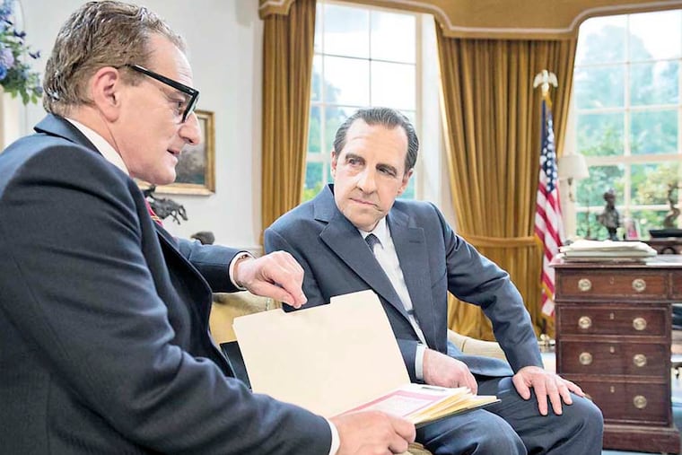 Henry Goodman as Henry Kissinger with folder and Harry Shearer as Nixon sitting.
Photo Credit: Justin Downing