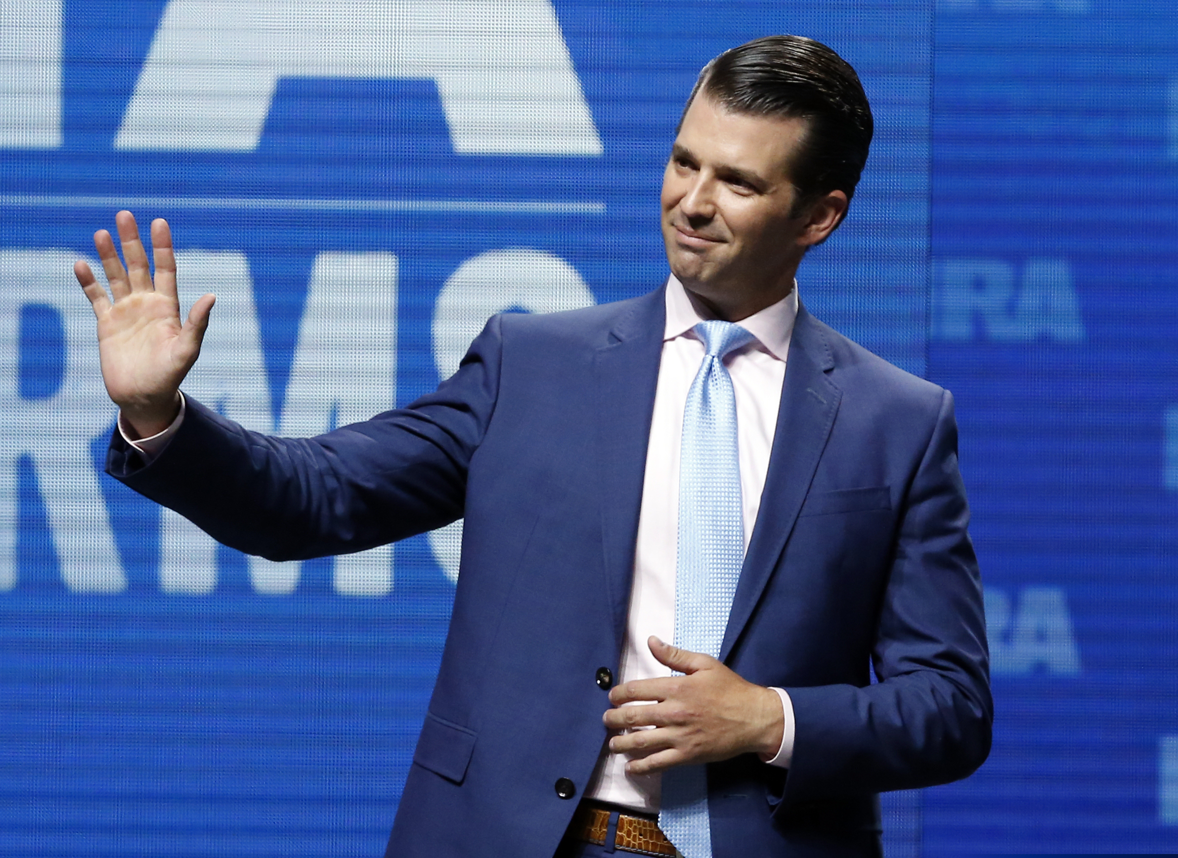 Donald Trump Jr. waves from the stage at the National Rifle Association in Dallas.