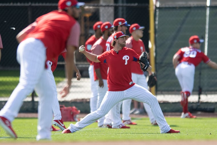Phillies pitcher Aaron Nola, center, warms up during spring workouts at Spectrum Field in Clearwater.