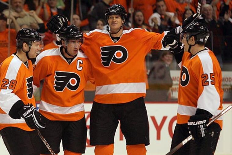 In a file photo (left to right), Claude Giroux, Mike Richards, Chris Pronger, and Matt Carle celebrate Richards' goal. Giroux passed Bobby Clarke as the longest-tenured captain in Flyers history Tuesday, and he said he models his leadership style after Richards.