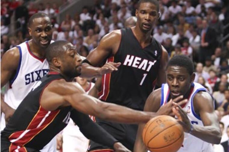 Jrue Holiday tries to keep the ball from the Heat's Dwyane Wade during the third quarter. (Steven M. Falk/Staff Photographer)