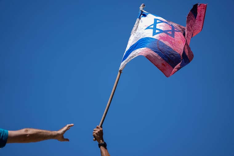 A demonstrator waves a colored Israeli flag during a protest against plans by Prime Minister Benjamin Netanyahu's government to overhaul the judicial system, outside the Knesset, Israel's parliament, in Jerusalem, on Monday.