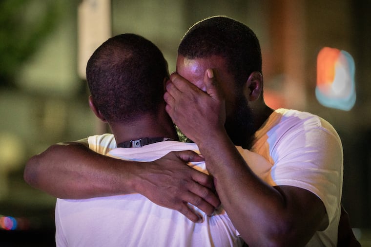 Sircarr Johnson Sr., right, outside of his son's clothing store, Premiére Bande, on 60th Street near Walnut in West Philadelphia, on July 4, 2021. His son, Sircarr Johnson Jr., 23, was killed in a shooting at a July 4th cookout in front of his store. Salahaldin Mahmoud, 21, was shot and killed, and a 16-year-old girl was injured.
