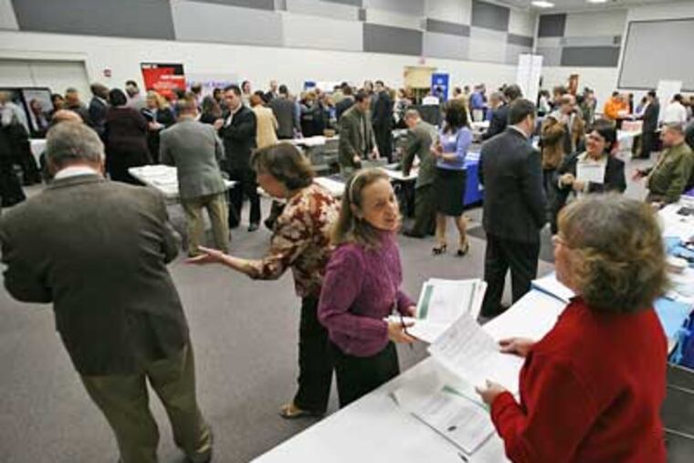 Former Circuit City paralegal Betsy Wade, center, hands her resume to recruiter Linda George, right, during a job fair at the headquarters of Circuit City in Richmond, Va. The government said Thursday that new claims for unemployment benefits jumped to their highest level in more than 26 years. (AP Photo/Steve Helber)