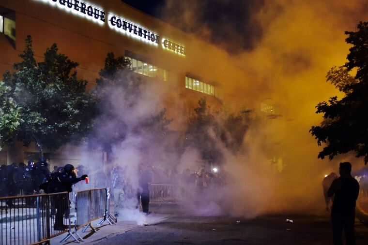 Officers deploy pepper spray outside a Trump rally in Albuquerque, N.M.