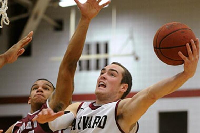 Harvard's Laurent Rivard drives toward the basket against Saint
Joseph's Chris Wilson. (Gretchen Ertl/AP)