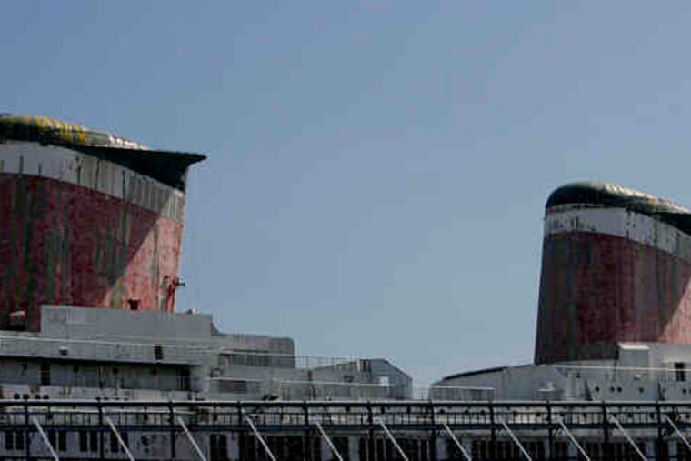 The SS United States, its smokestacks towering above the pier, was built as a luxury passenger liner that could be converted toa troop carrier. It was removed from service in 1969. Supporters hope the lighting ceremony is a signal of better days ahead.