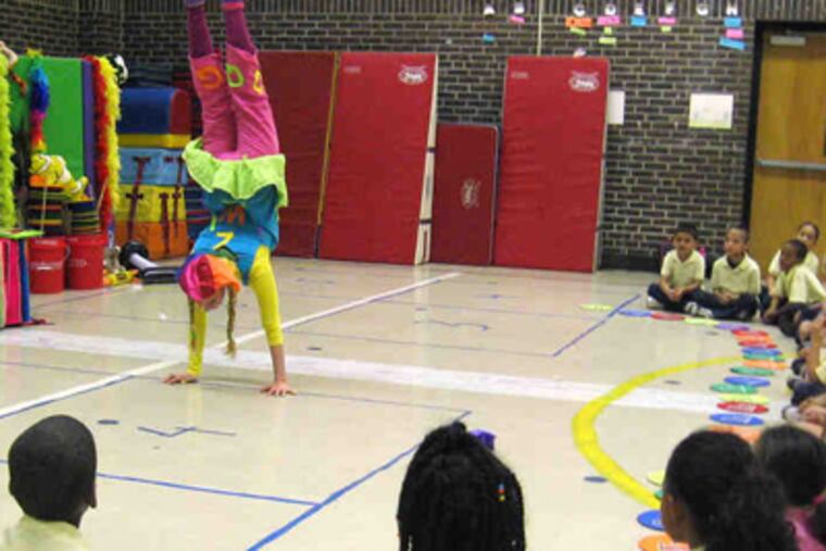Lisa Appel does a handstand while reading a book, combining the physical with the mental. She says her program works as well with math and science, too.