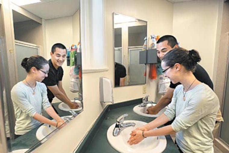 Katie Schaffer, 20, washes up in the coed bathroom next to Michael Shin, also 20, who lives down the hall in her dorm at Swarthmore. She lives with a male friend. (Sharon Gekoski-Kimmel / Staff Photographer)