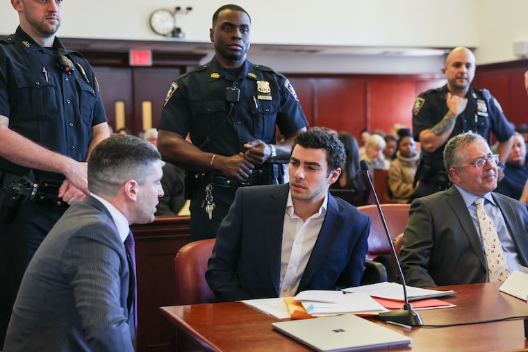 Luigi Mangione (center) appears in Manhattan Criminal Court for an evidence hearing last month in New York.