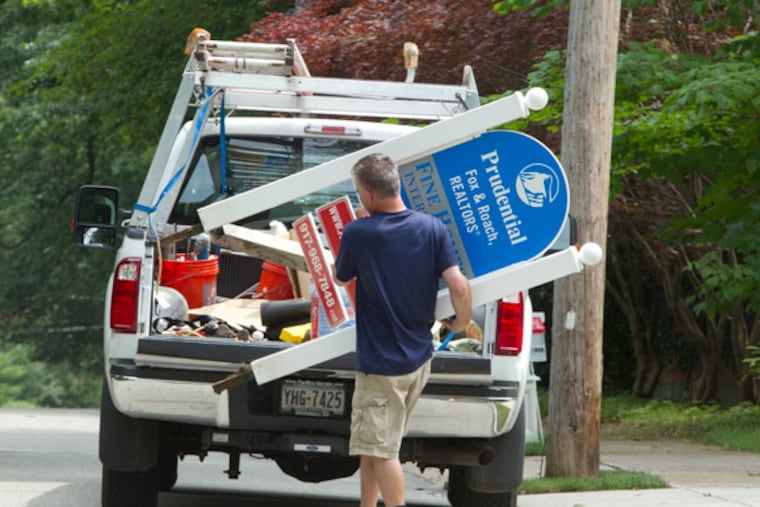 An unidentified maintenance worker removes the for sale sign from 117 Booth Road, Haverford, late Thursday morning. ( Ed Hille / Staff Photographer )