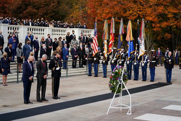 President Joe Biden stands with Veterans Affairs Secretary Denis McDonough and Army Maj. Gen. Allan M. Pepin during a wreath laying ceremony to commemorate Veterans Day and mark the centennial anniversary of the Tomb of the Unknown Soldier at Arlington National Cemetery.