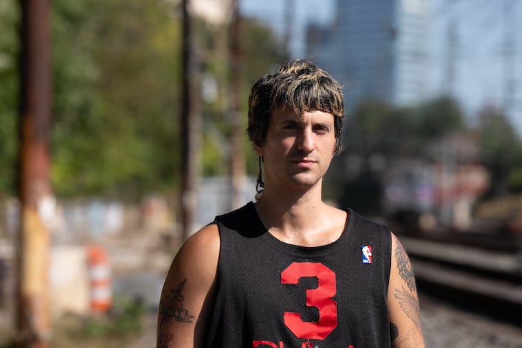 Doug Dulgarian at the railroad tracks adjacent to Woodlands Cemetery in West Philadelphia in October 2025. His band They Are Gutting A Body Of Water will celebrate their acclaimed new album 'LOTTO' with shows at the Furst Unitarian Church in Center City on Dec. 12, 13 and 19.