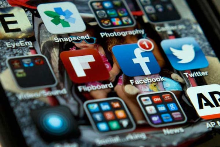 A view of an iPhone, showing the Twitter and Facebook apps among others. A new poll finds that teens are sharing more about themselves on social media. They’re also moving increasingly to Twitter to avoid their parents and the "oversharing" that they see on Facebook. (AP Photo/Evan Vucci)