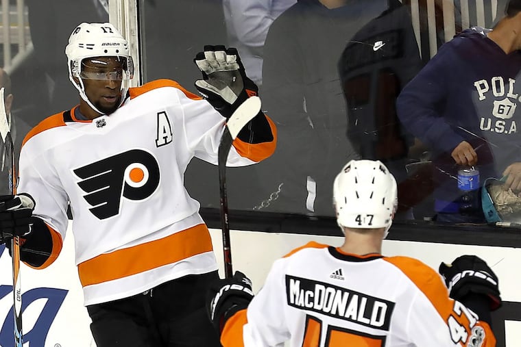 Wayne Simmonds (left) celebrates with Andrew MacDonald after completing his hat trick in the Flyers’ season- opening win Oct. 4 in San Jose.