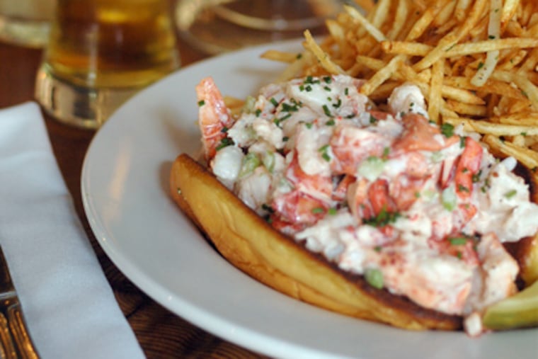 A New England lobster roll (left) served with shoestring fries and a glass of beer.