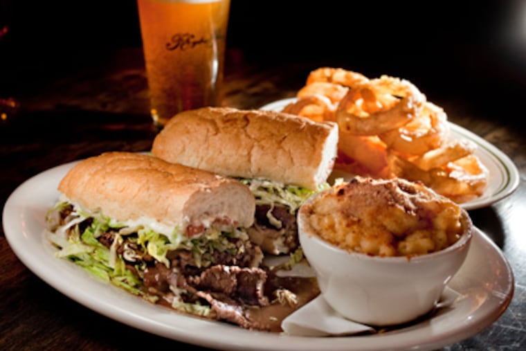 Sloppy, tender roast beef po-boy with "debris" gravy, on genuine Leidenheimer bread from New Orleans, with a pint of Ballast Point Yellowtail ale. (DAVID M WARREN / Staff Photographer)