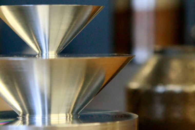 In foreground on left is a burner tip for a furnace and the tall item in background on right is a stainless steel freeze drier door lock all made by Windle-Excel Machine Solutions. ( Elizabeth Robertson / Staff Photographer )