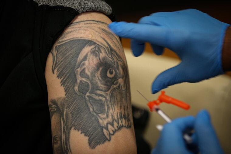 Jonathan Martinez, 34, receives the COVID-19 vaccine from Richard Lawrence at the vaccine clinic at the Veterans Affairs hospital in Philadelphia on Monday.