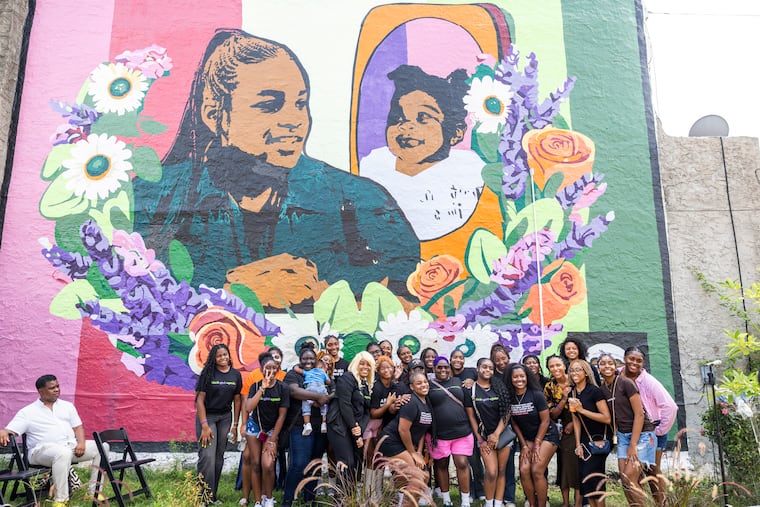 We REIGN takes a group photo in front of a new mural celebrating Black girlhood located at 41st and Wallace Streets, in Philadelphia, on Saturday.