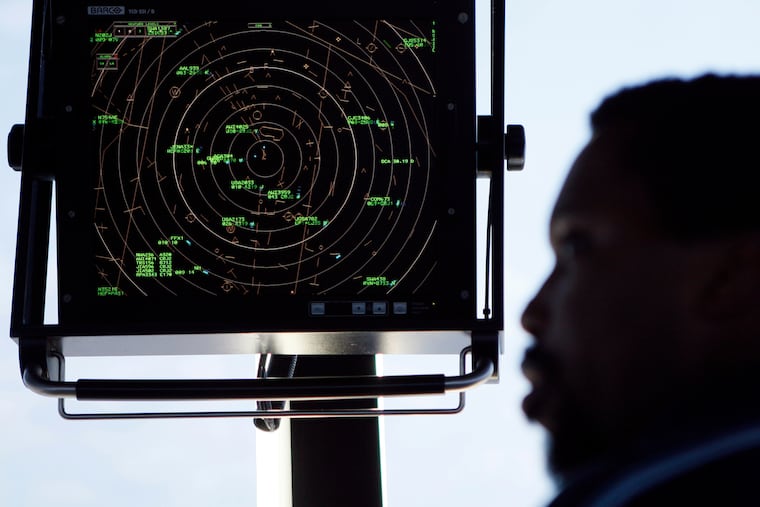 Aair traffic controller stands beneath a radar screen in the control tower at Washington's Reagan National Airport in 2008. “To reach the next generation of air traffic controllers, we need to adapt,” Transportation Secretary Sean Duffy said in a release Friday about the new hiring campaign.