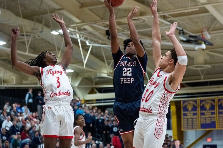 Holy Ghost Prep's Adrien Varella (center) goes up for a shot against Upper Dublin during the District 1 Class 5A championship in February.