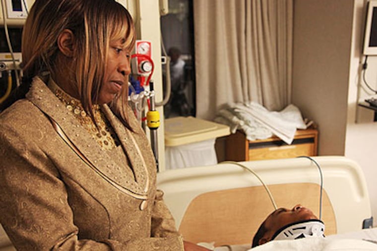 Vermell Mitchell stands by her son, Mazeratti, who is refusing medications at Thomas Jefferson University Hospital that could help heal his spine after a wrestling injury. The Mitchells received a letter last week from Delaware County's Children and Youth Services saying their son had been taken into protective custody. (Rachel Gouk / Staff Photographer)