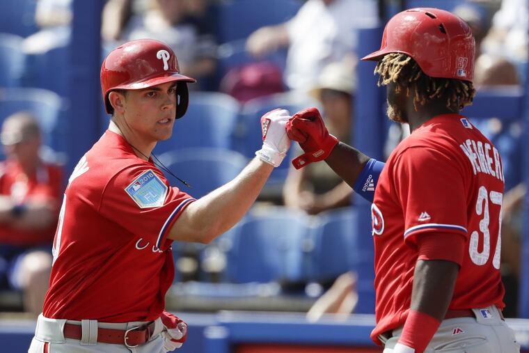 Scott Kingery celebrates his solo home run with teammate Odubel Herrera (right).