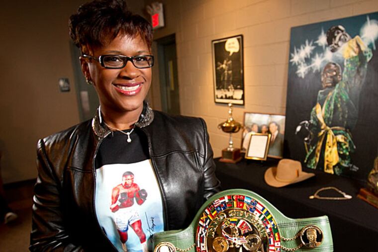 The daughter of Joe Frazier, Weatta Collins with a World Boxing Council belt in front of a display of items being auctioned by Hunt Auctions of Exton, PA. (Alejandro A. Alvarez/Staff Photographer)