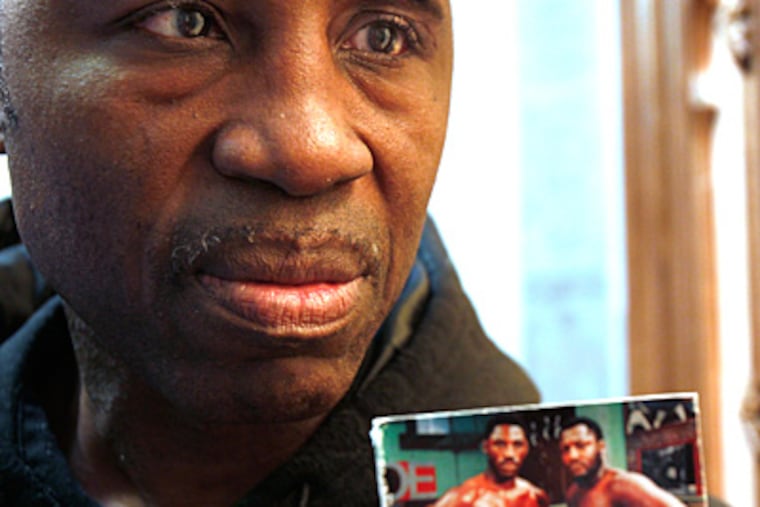 Marvis Frazier holds up a picture of himself with his famous dad, Smokin’ Joe Frazier. (David Maialetti/Staff file photo)