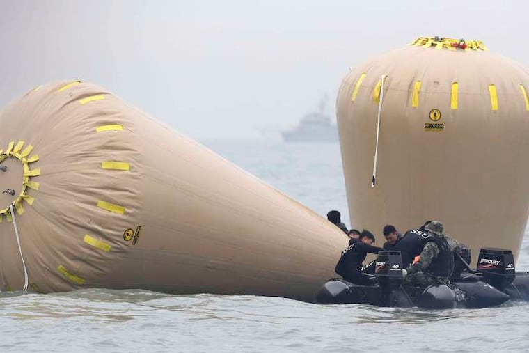 Rescue crews mark the spot where the ferry Sewol sank Friday off South Korea. The vessel's captain and two crew members were arrested on suspicion of negligence. Divers began pumping air into the ferry to save any survivors among the 270 aboard.