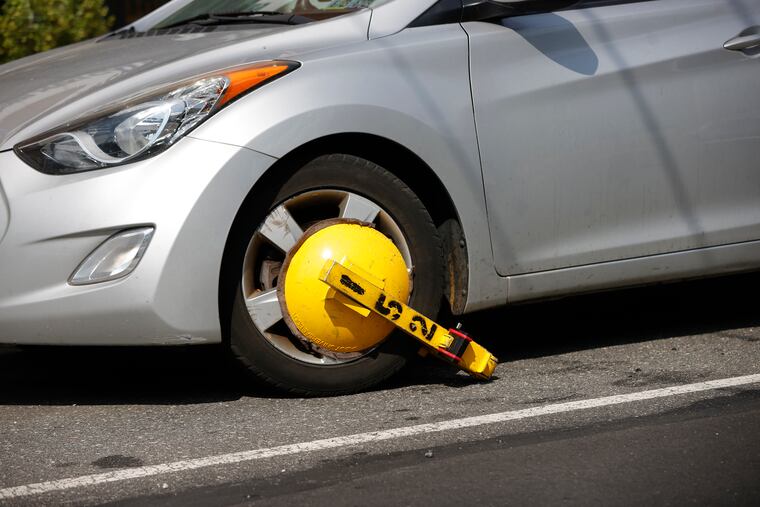 A car in Philadelphia with a “boot” attached to its front wheel in July.