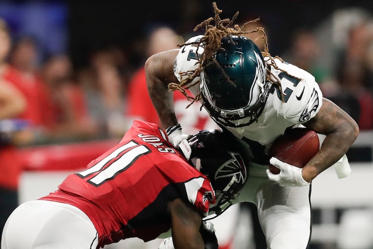 Eagles cornerback Ronald Darby is hit by Atlanta's Julio Jones after Darby intercepted the ball.