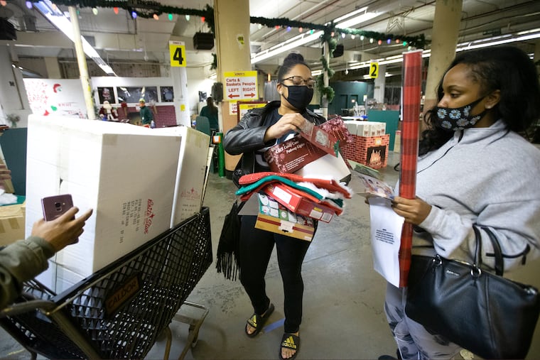 Maria Chavarria, left, and Jasmin Harris and others divide their items before checking out at Kindy’s Christmas Factory Outlet Store.