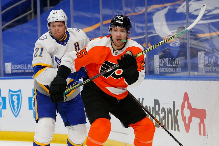 Buffalo's Kyle Okposo (21) and Flyers left winger James van Riemsdyk (25) battle behind the net during the first period Sunday. Van Riemsdyk's second-period goal gave the Flyers a 3-0 lead.