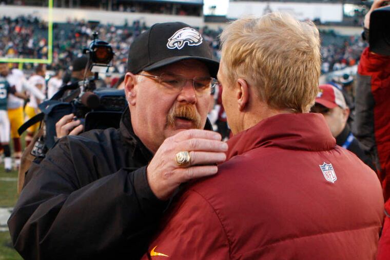 Andy Reid is embraced by Redskins defensive coordinator Jim Haslett after Washington beat the Eagles in what could be Reid's last home game. RON CORTES / Staff