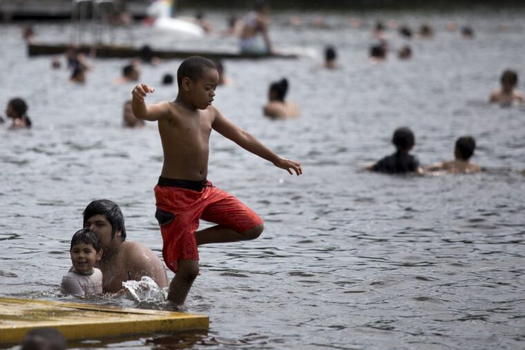 Amare Turner, 8, jumps off a dock and into Garrison Lake in Monroeville, NJ.