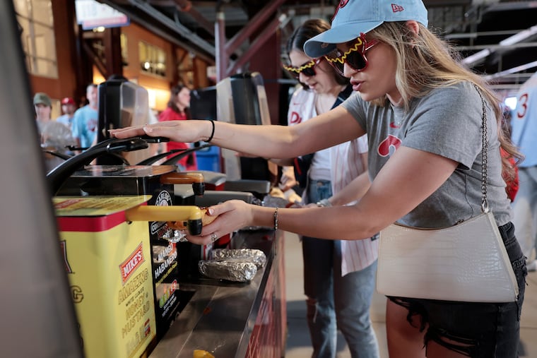 Eleni Rodriguez (right) and Maria Clauser of Philadelphia add some condiments to their hot dogs during Hatfield Phillies Franks BOGO Night during a Phillies game against the Nationals.